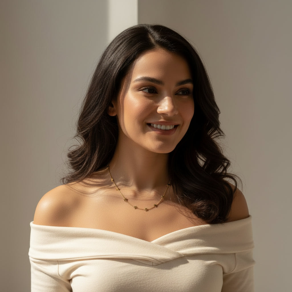 Woman wearing an off-shoulder top styling a beautiful neckpiece with a neutral background